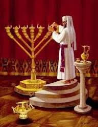 man in white robe lighting menorah